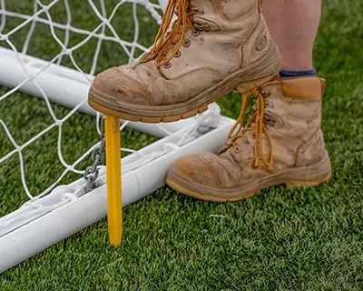 Inserting a secure polycarbonate Supa-Peg to keep portable football goals grounded